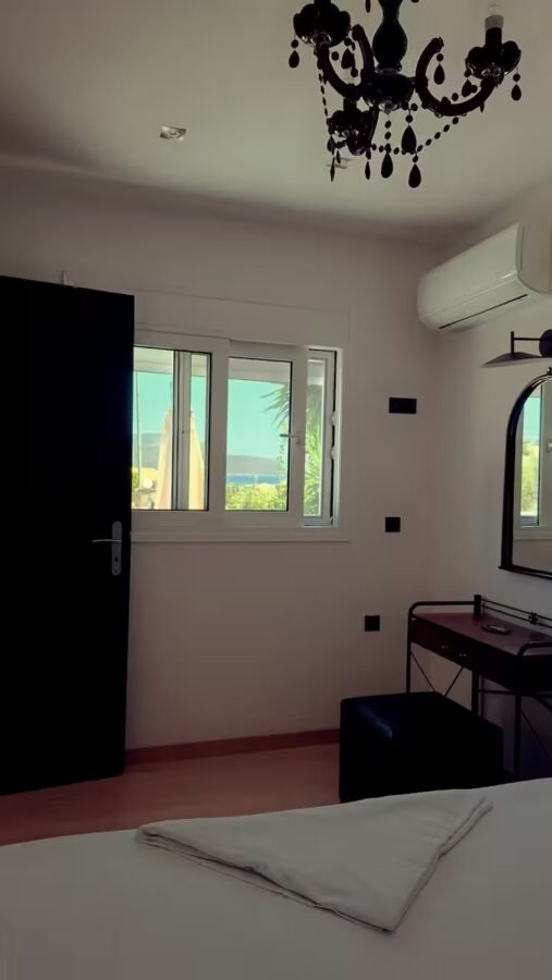 Bedroom with chandelier and windows onto the countryside