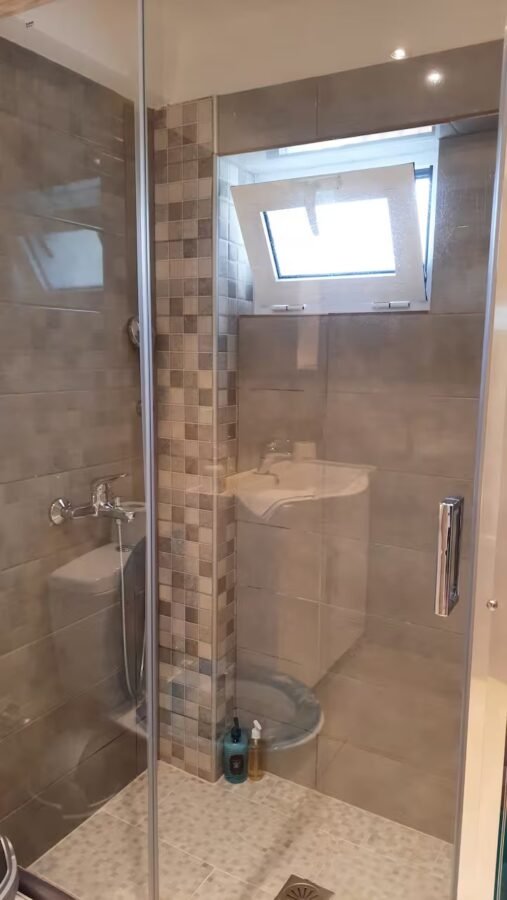 Glass shower enclosure in the studio bathroom